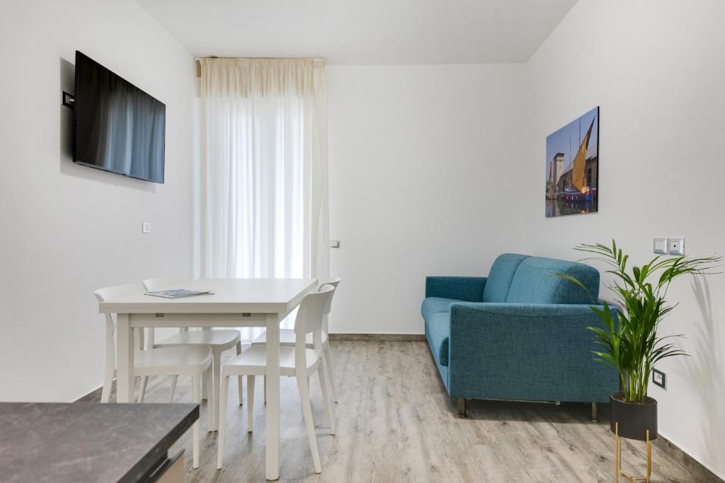 - un salon avec une table et une chaise bleue dans l'établissement Elegance Suite Apartments - Siroli Collection, à Cervia