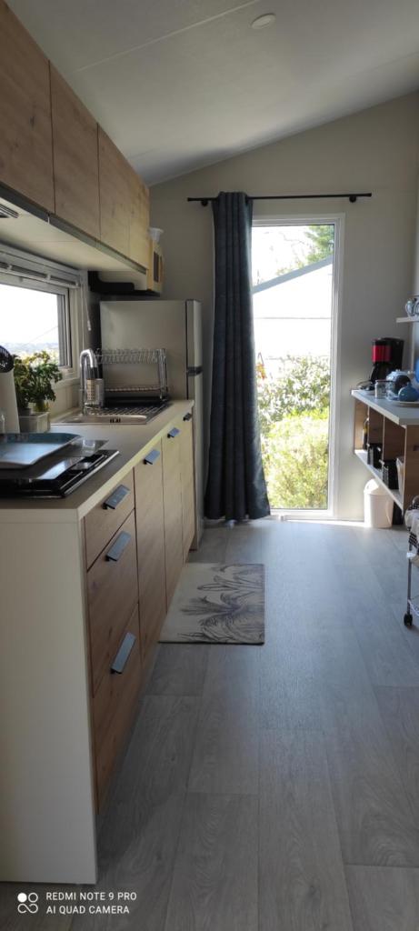 une cuisine avec des placards en bois et une grande fenêtre dans l'établissement Baia 1, à Drammont 12 autres photos