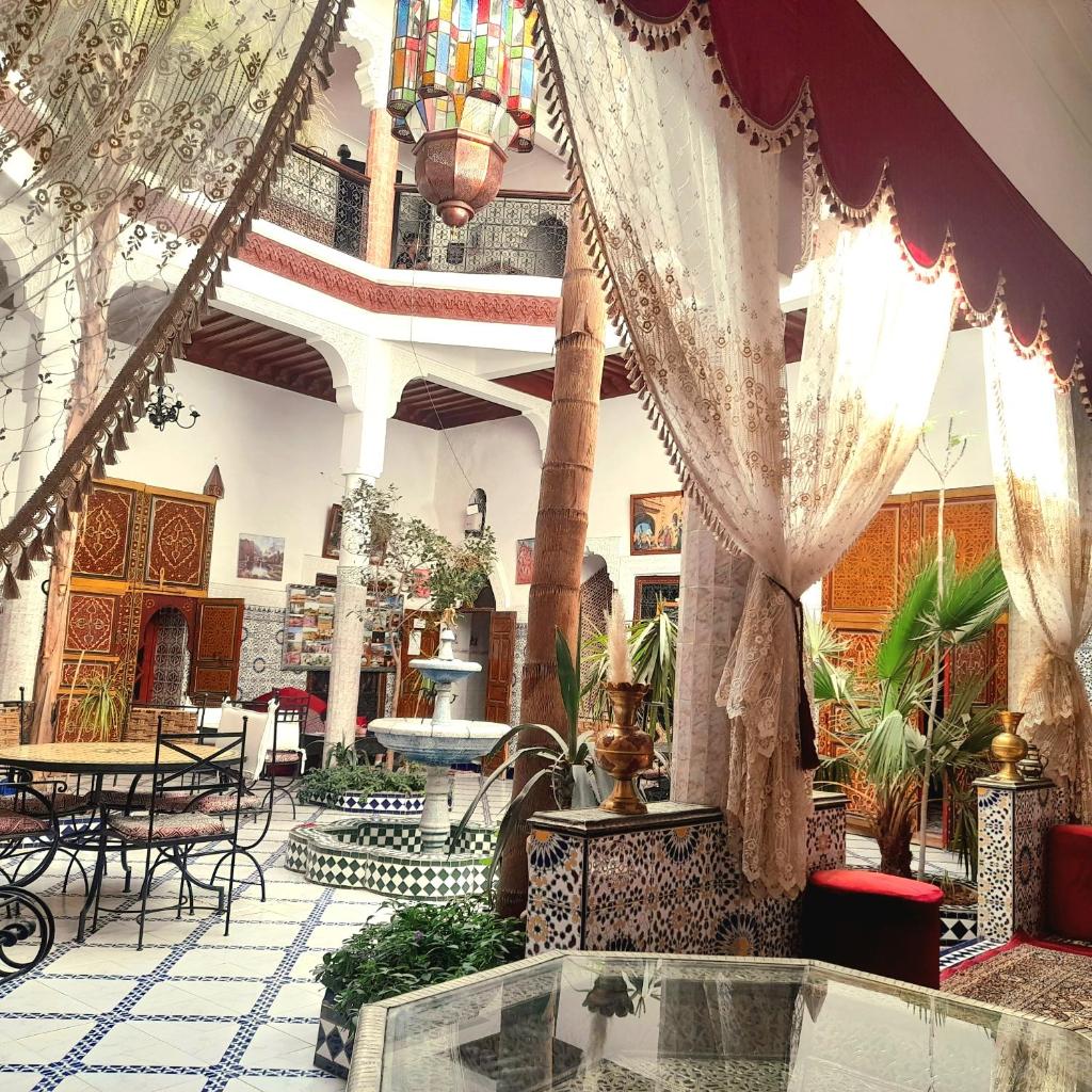 un hall avec des tables et des chaises dans un bâtiment dans l'établissement Riad Chennaoui, à Marrakech