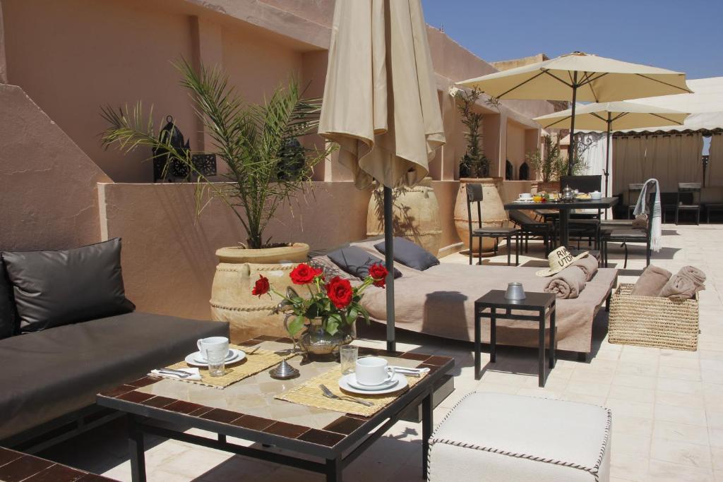 - un salon avec un canapé, des tables et un parasol dans l'établissement Riad Utopia Suites And Spa, à Marrakech 37 autres photos