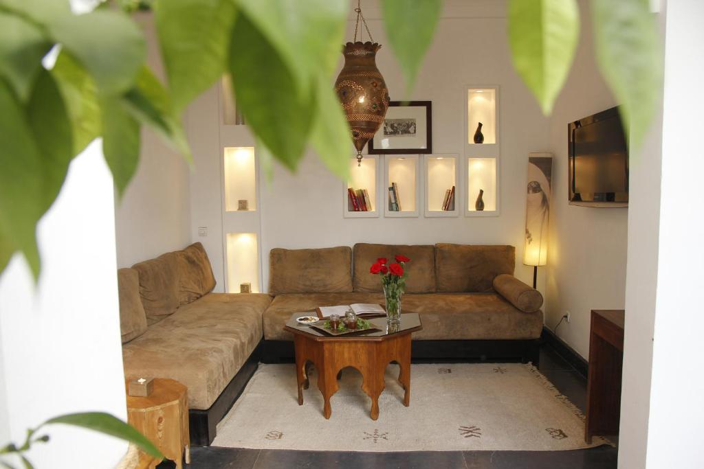 un salon avec un canapé et une table dans l'établissement Riad Utopia Suites And Spa, à Marrakech