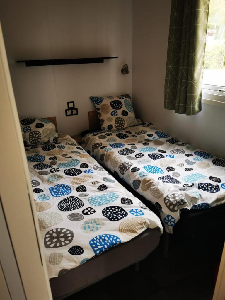 deux lits jumeaux dans une chambre avec dans l'établissement Mobil home neuf camping l ile dor plage st raphael avec piscine, à Saint-Raphaël