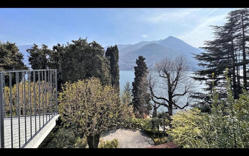 une porte avec des arbres et une montagne en arrière-plan dans l'établissement Villa Sole Carate Urio – Lake Como, à Carate Urio