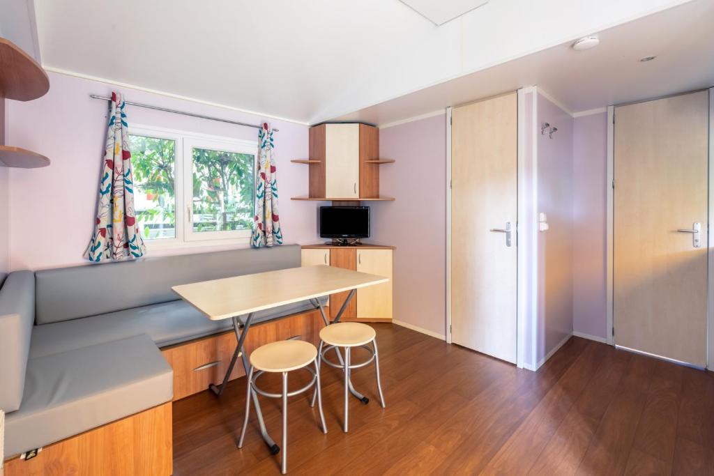 une cuisine avec une table et deux tabourets dans l'établissement Camping Lou Cabasson, à Bormes-les-Mimosas