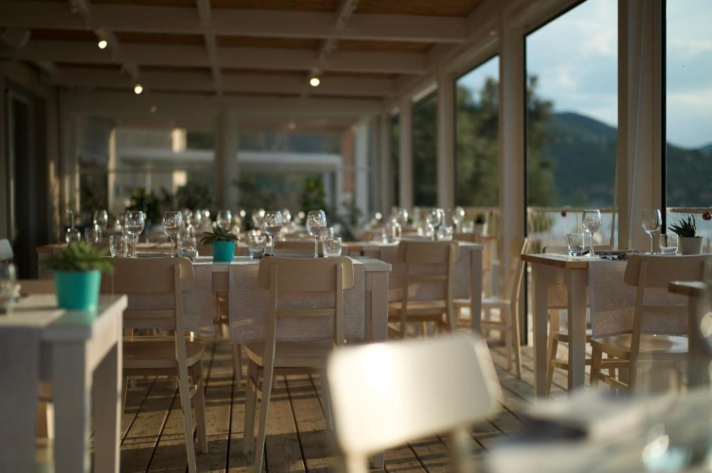 un restaurant avec des tables et des chaises avec des verres à vin dans l'établissement Hotel Villa Ambra, à Orbetello