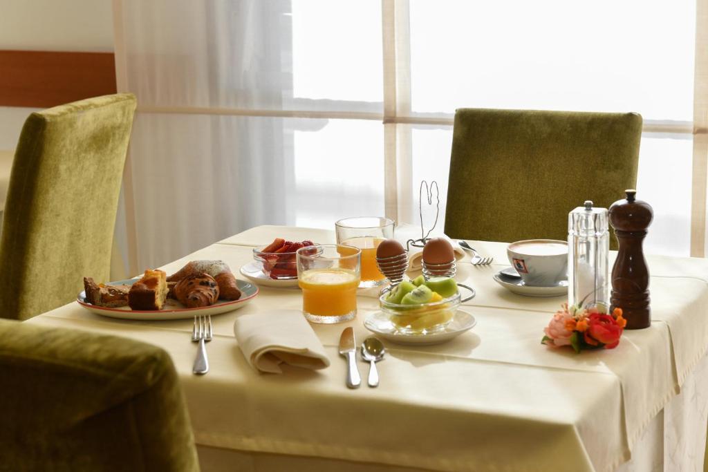 une table avec des aliments et des boissons pour le petit-déjeuner dans l'établissement Hotel Vienna, à Lido di Jesolo 47 autres photos
