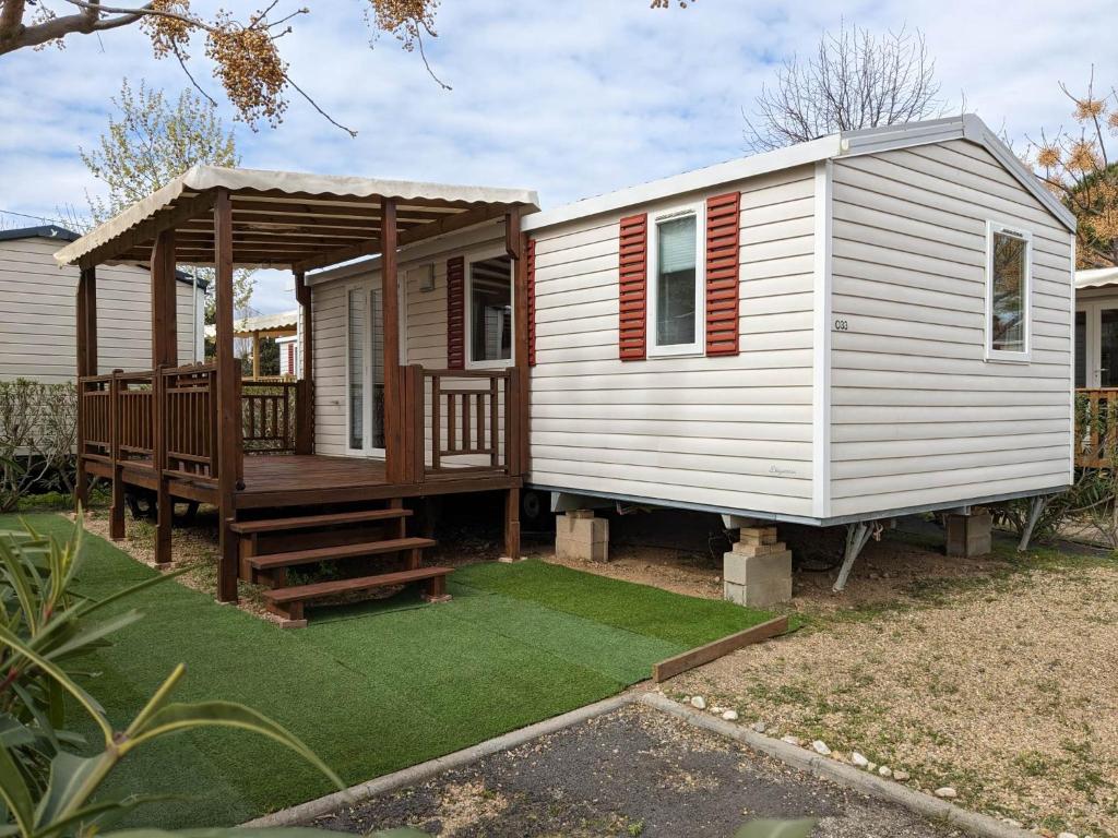 une petite maison avec un porche et une terrasse dans l'établissement Mobil'home Valras, à Valras-Plage