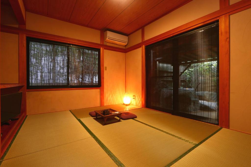 une pièce avec une salle de méditation avec une table et deux fenêtres dans l'établissement YamakawaZENZO, à Oguni