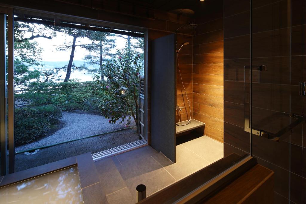 La salle de bains est pourvue d'une douche et d'une grande fenêtre. dans l'établissement Monjusou Shourotei, à Miyazu