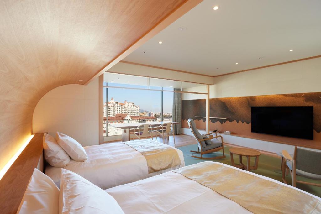 une chambre d'hôtel avec deux lits et une télévision à écran plat dans l'établissement Hotel Wakamizu, à Takarazuka