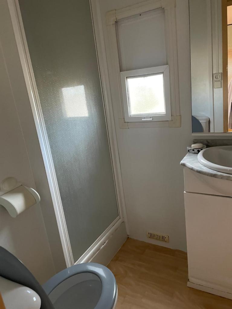 une salle de bain avec toilettes, lavabo et fenêtre dans l'établissement Gard les Dolmens, à Méjannes-le-Clap
