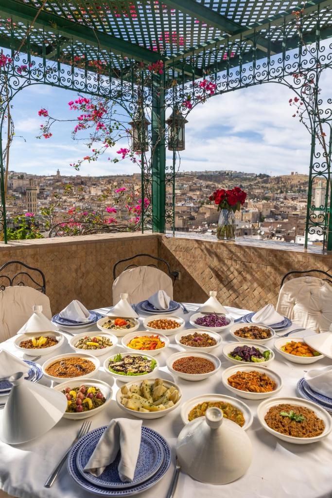 une table avec de nombreuses assiettes de nourriture dessus dans l'établissement Palais De Fès Suites & Spa, à Fès