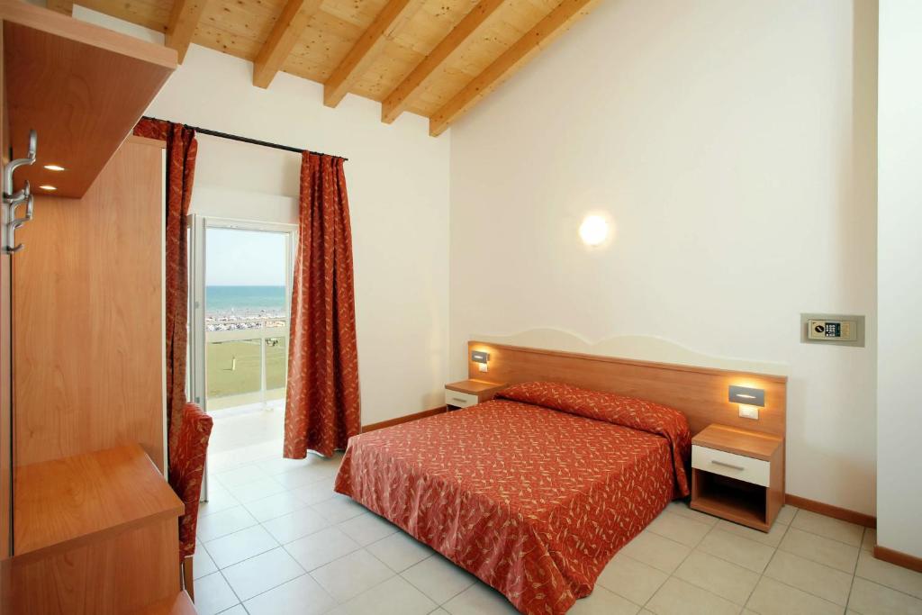 une chambre avec un lit et une vue sur l'océan dans l'établissement Hotel Villa Olga, à Caorle