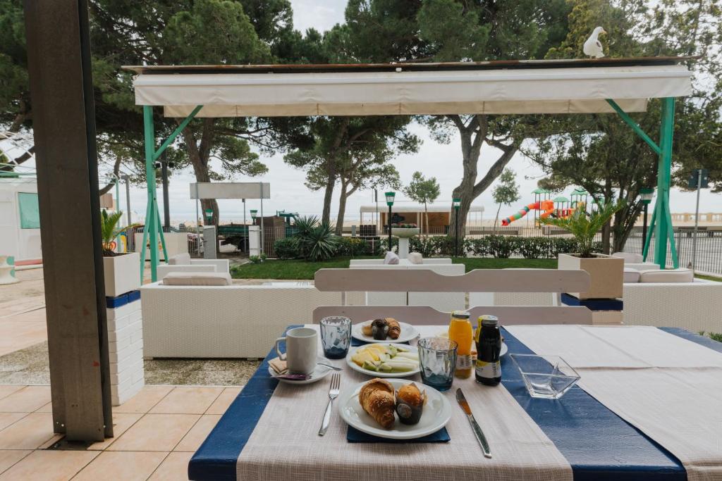 une table avec deux assiettes de nourriture dessus dans l'établissement Hotel Villa Franca, à Lignano Sabbiadoro