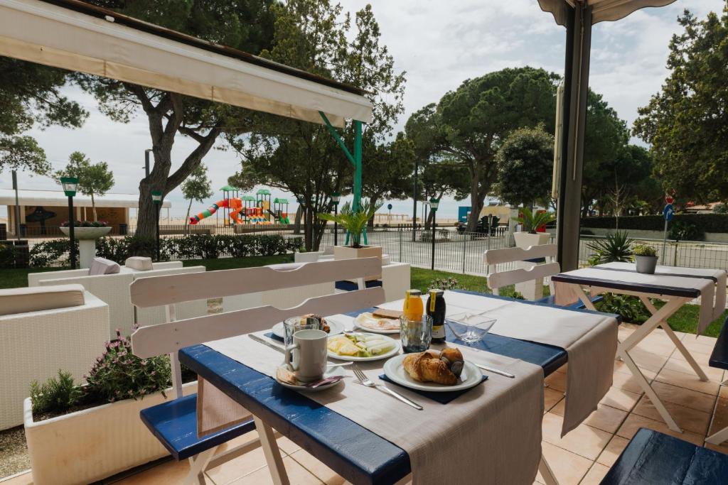 une table avec une assiette de nourriture au-dessus dans l'établissement Hotel Villa Franca, à Lignano Sabbiadoro