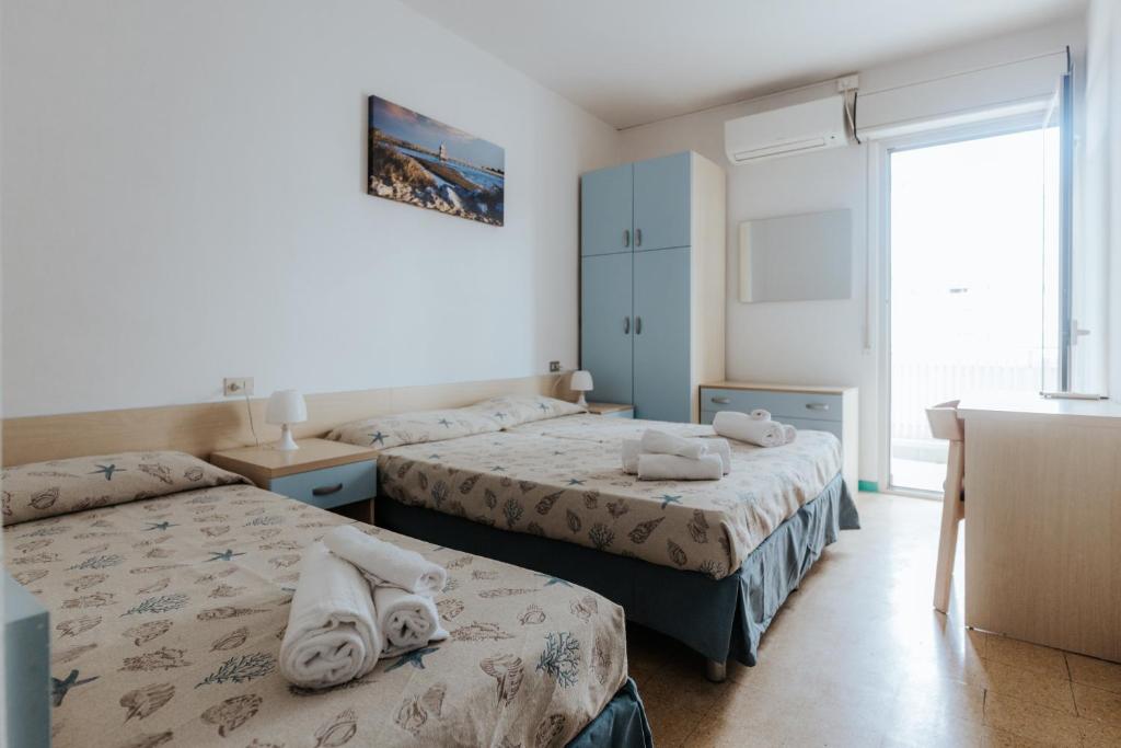 une chambre avec deux lits avec des serviettes dessus dans l'établissement Hotel Villa Franca, à Lignano Sabbiadoro