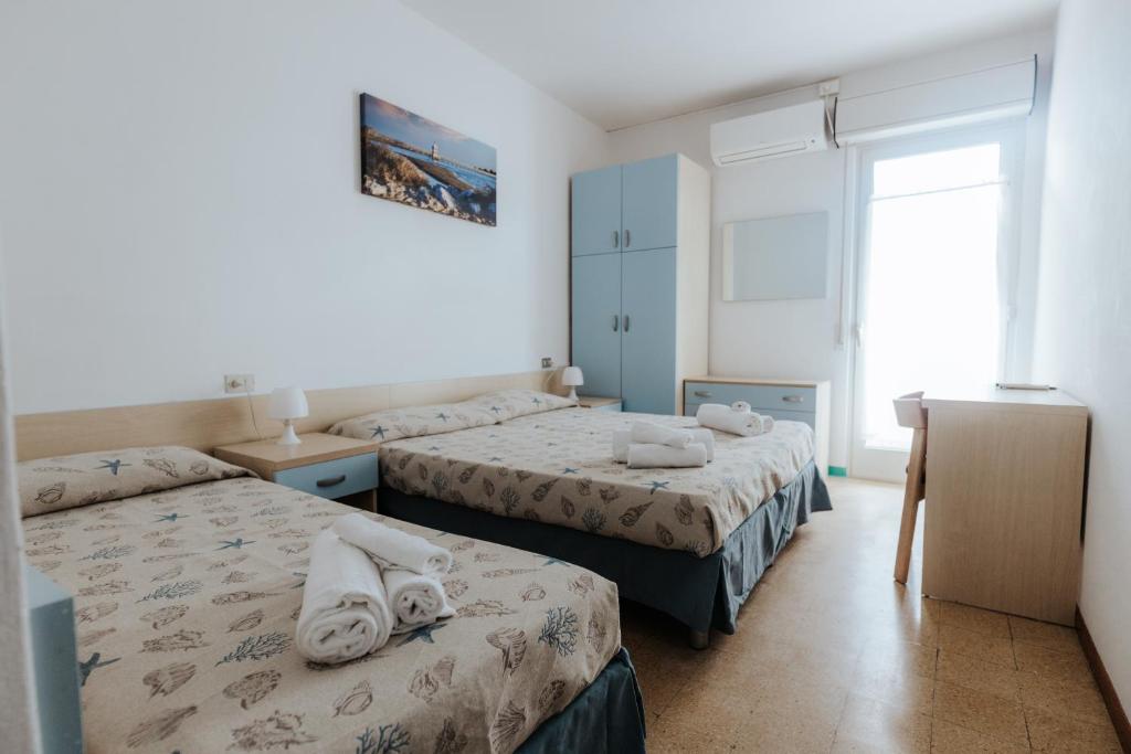 une chambre d'hôtel avec deux lits et une fenêtre dans l'établissement Hotel Villa Franca, à Lignano Sabbiadoro 72 autres photos