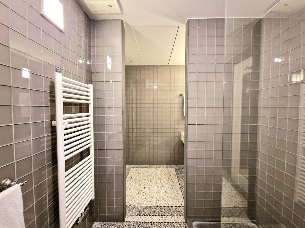 La salle de bains est pourvue d'une douche et de murs carrelés gris. dans l'établissement Roccobarocco Boutique Hotel, à Ischia 53 autres photos