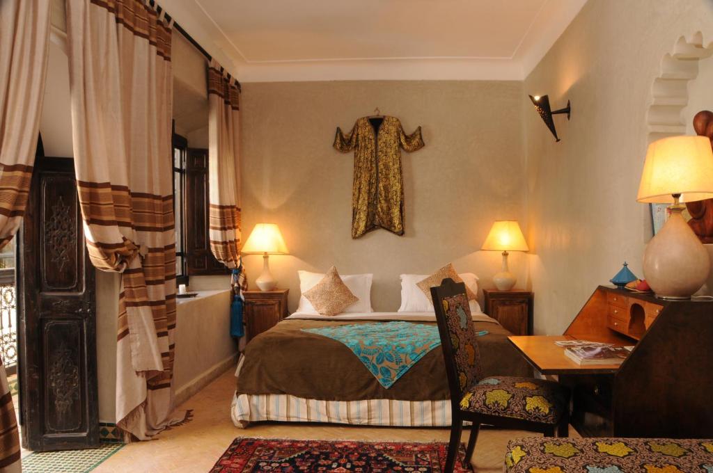 - une chambre avec un lit et une traverse suspendue au mur dans l'établissement Riad Saba, à Marrakech