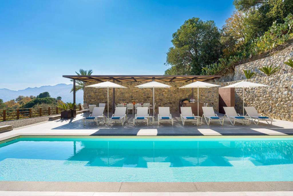 une piscine avec chaises et parasols dans l'établissement Zagara Bianca, à Savoca