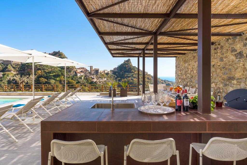 un patio avec une table et des chaises et une piscine dans l'établissement Zagara Bianca, à Savoca