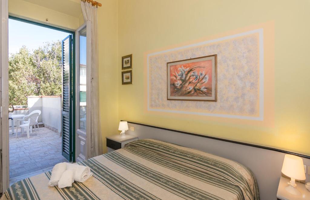 une chambre avec un lit et une porte coulissante en verre dans l'établissement Hotel Stella Del Mare, à Viareggio