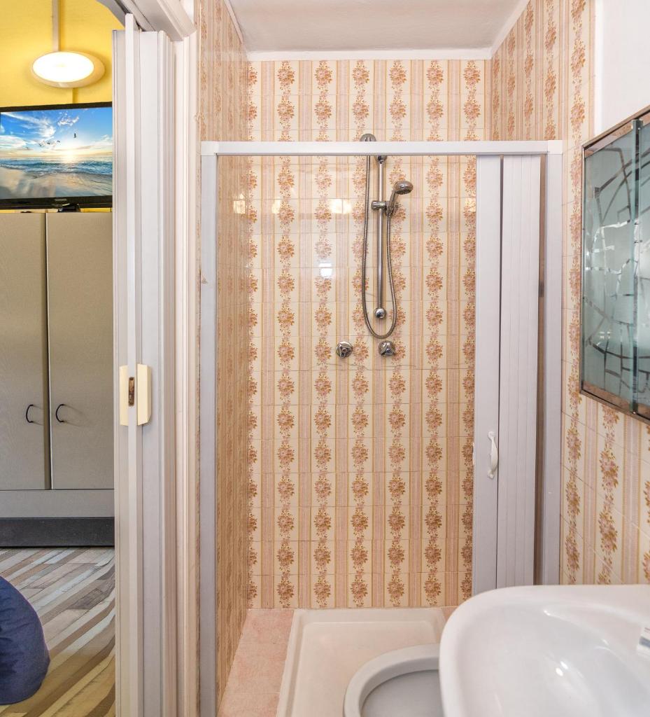 une salle de bain avec douche et lavabo dans l'établissement Hotel Stella Del Mare, à Viareggio