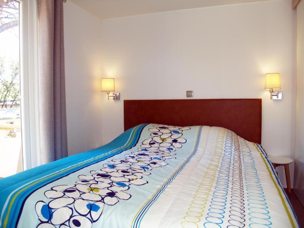 un grand lit dans une chambre avec deux lampes dans l'établissement Camping, au Muy 32 autres photos