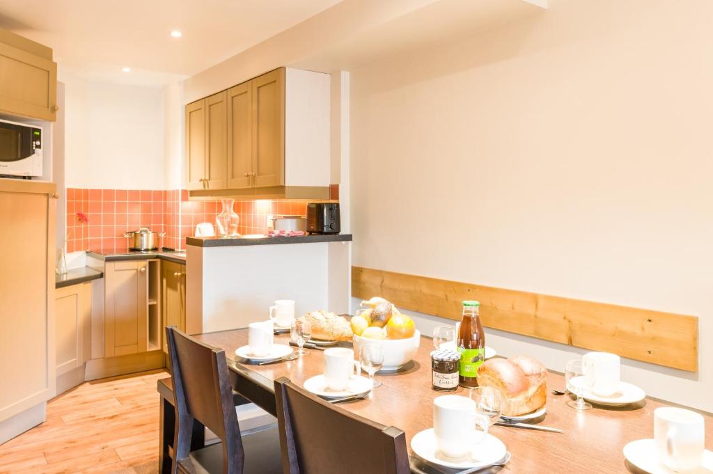 une cuisine avec une table en bois avec des chaises et une tableasteryasteryasteryasteryasteryastery dans l'établissement Résidence Pierre & Vacances Le Tikal, à Val Thorens