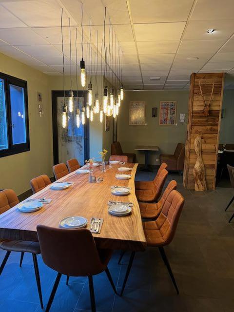 une grande table en bois dans une pièce avec des chaises dans l'établissement Large premium alpine apartment for 4 to 8 people, à Vallorcine