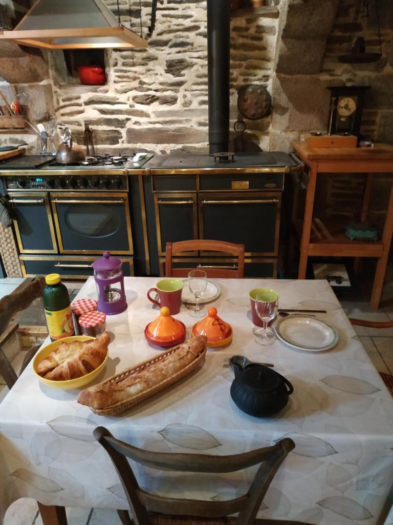 une table avec un tissu de table blanc et de la nourriture dans l'établissement Thipi Khola, à Val Couesnon