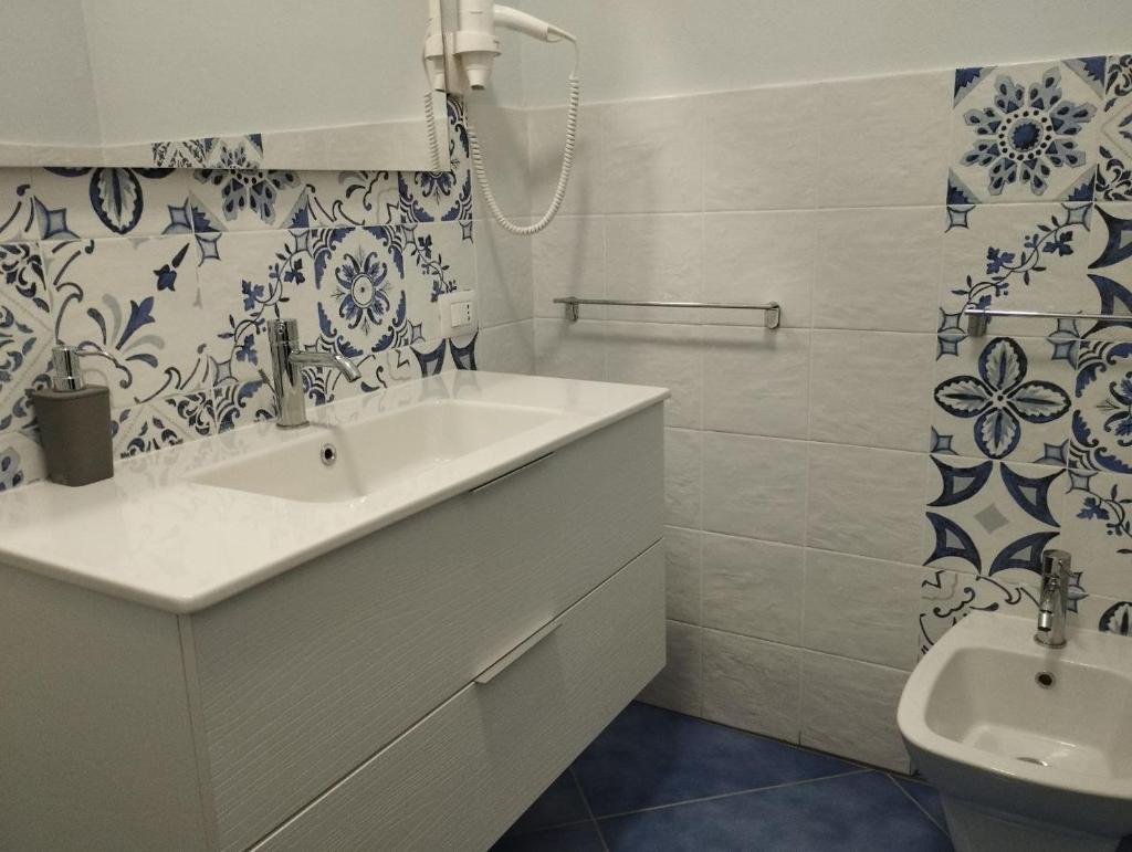 une salle de bain blanche avec un lavabo et des toilettes dans l'établissement Hotel La Giara, à Zambrone