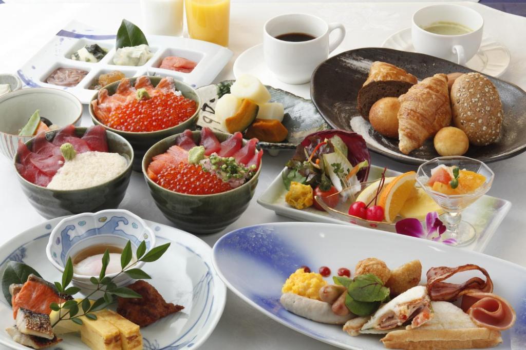 une table recouverte de assiettes et de bols de nourriture dans l'établissement Yunokawa Prince Hotel Nagisatei, à Hakodate