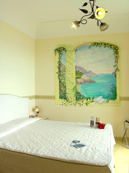une chambre avec un lit avec un tableau sur le mur dans l'établissement Locanda Degli Agrumi, à Conca dei Marini