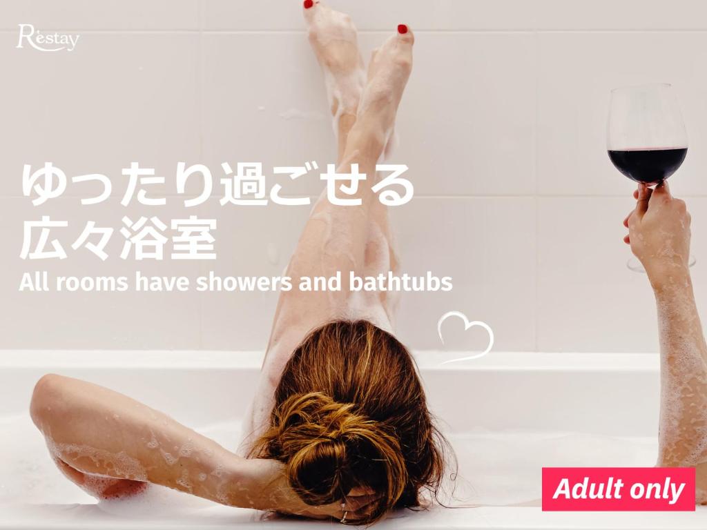 une femme allongée dans un bain avec un verre de vin dans l'établissement Restay Tokushima Aine (Adult Only), à Tokushima