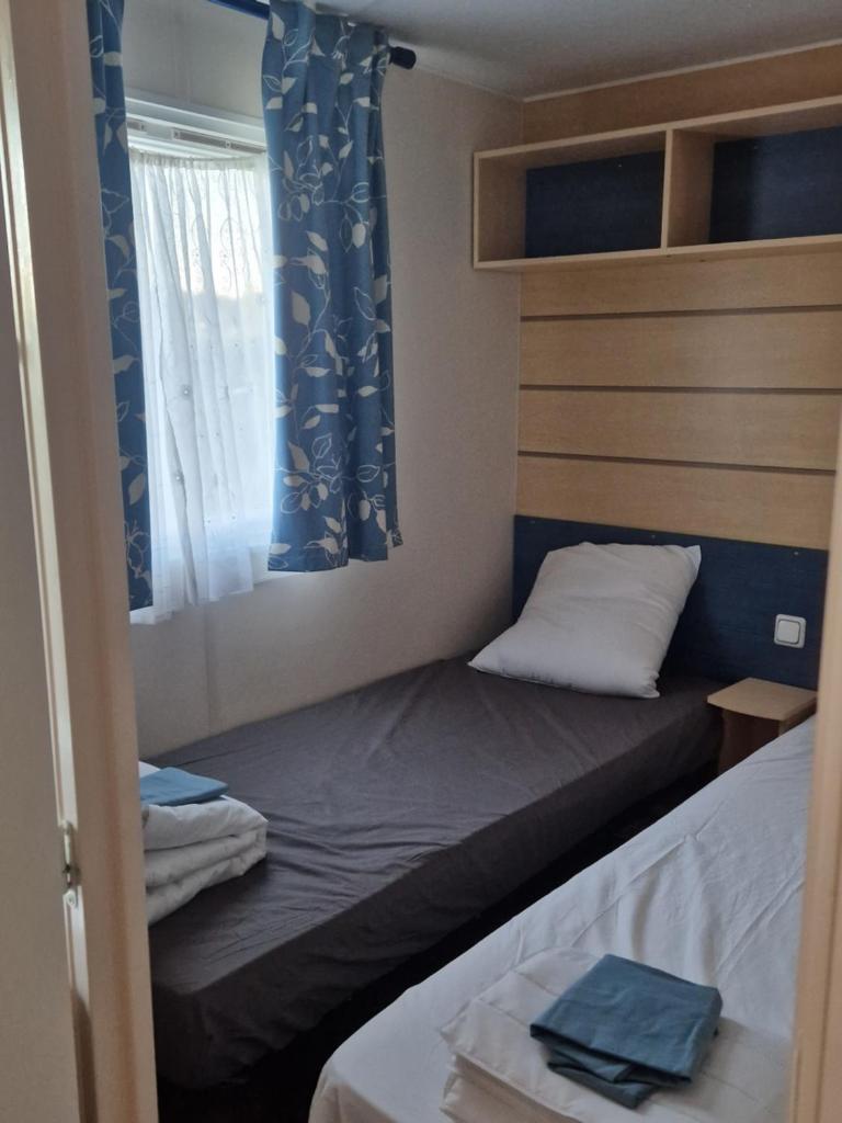 une petite chambre avec deux lits et une fenêtre dans l'établissement Mazet d El gato, à Arles