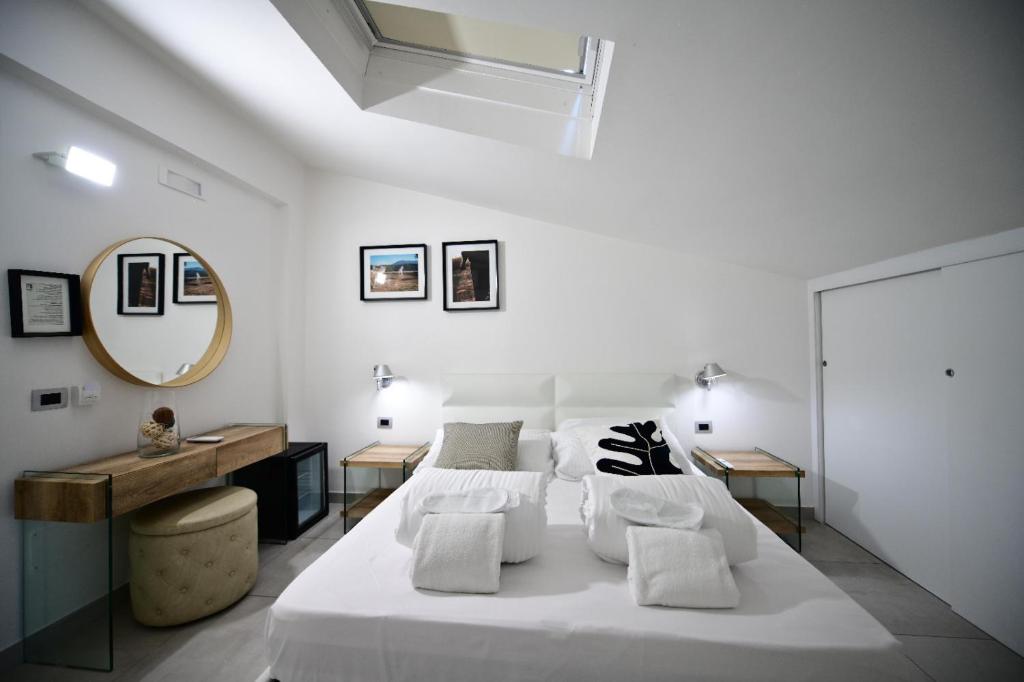 - une chambre blanche avec 2 lits et un miroir dans l'établissement Hotel Royal Paestum, à Paestum