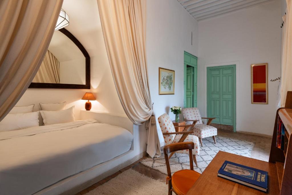 une chambre avec un lit, une chaise et une table dans l'établissement Riad Kitula, à Marrakech