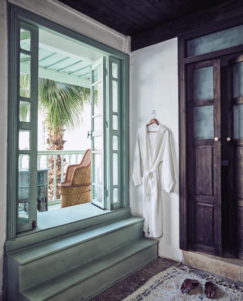 un costume blanc est suspendu dans une fenêtre dans l'établissement Riad Kitula, à Marrakech