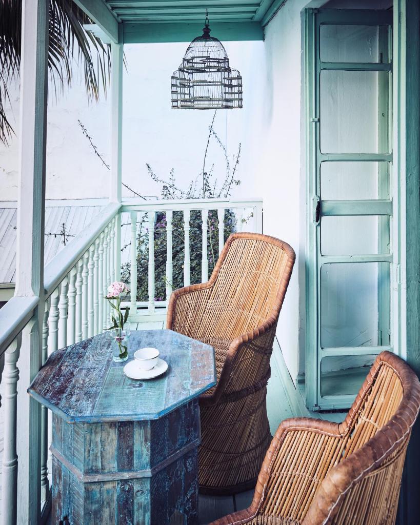 - une terrasse couverte avec 2 chaises et une table sur un balcon dans l'établissement Riad Kitula, à Marrakech
