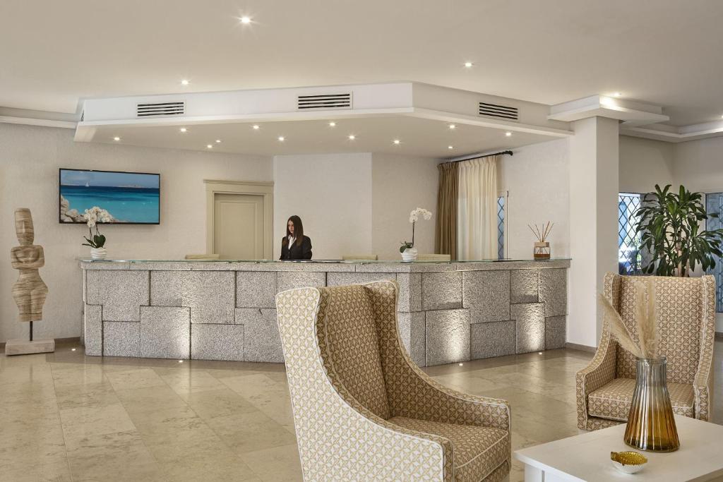 une femme debout à la réception dans le hall dans l'établissement Grand Hotel Cannigione, à Cannigione 83 autres photos