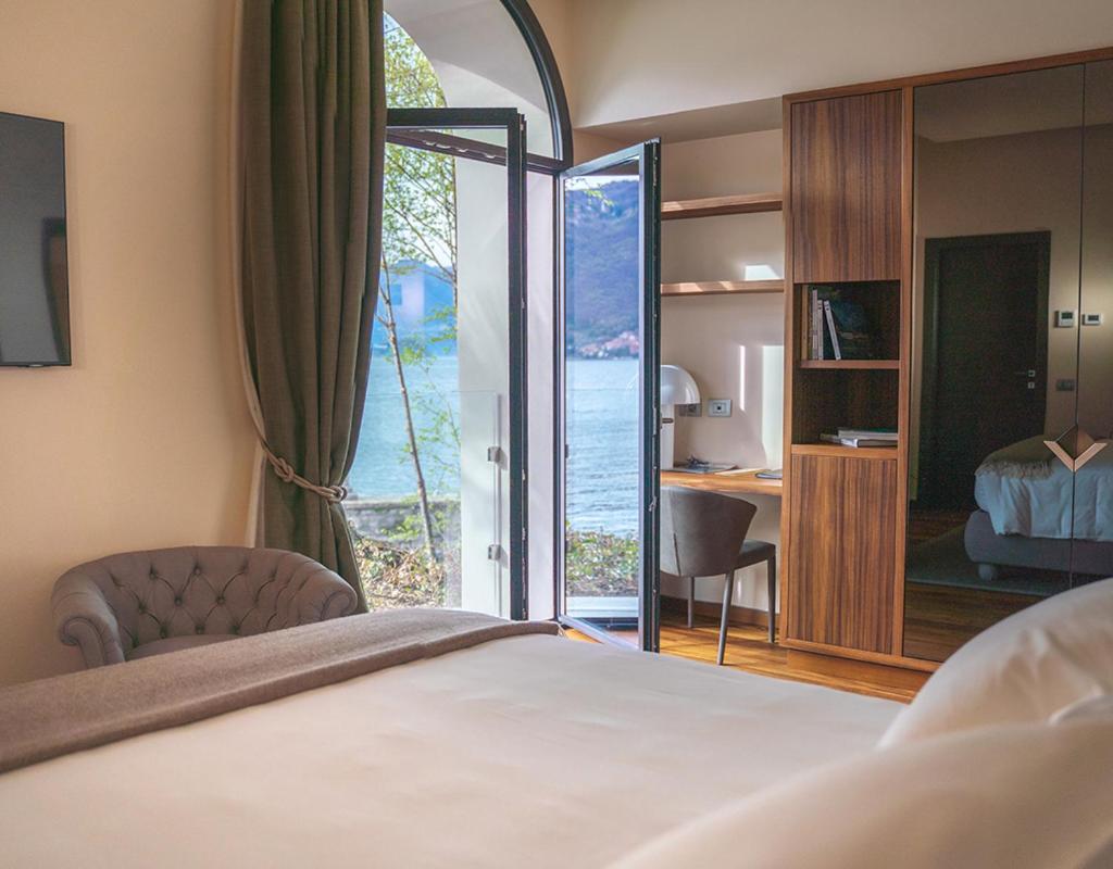 une chambre avec un lit et une vue sur l'océan dans l'établissement Villa Lario Resort Mandello, à Mandello del Lario
