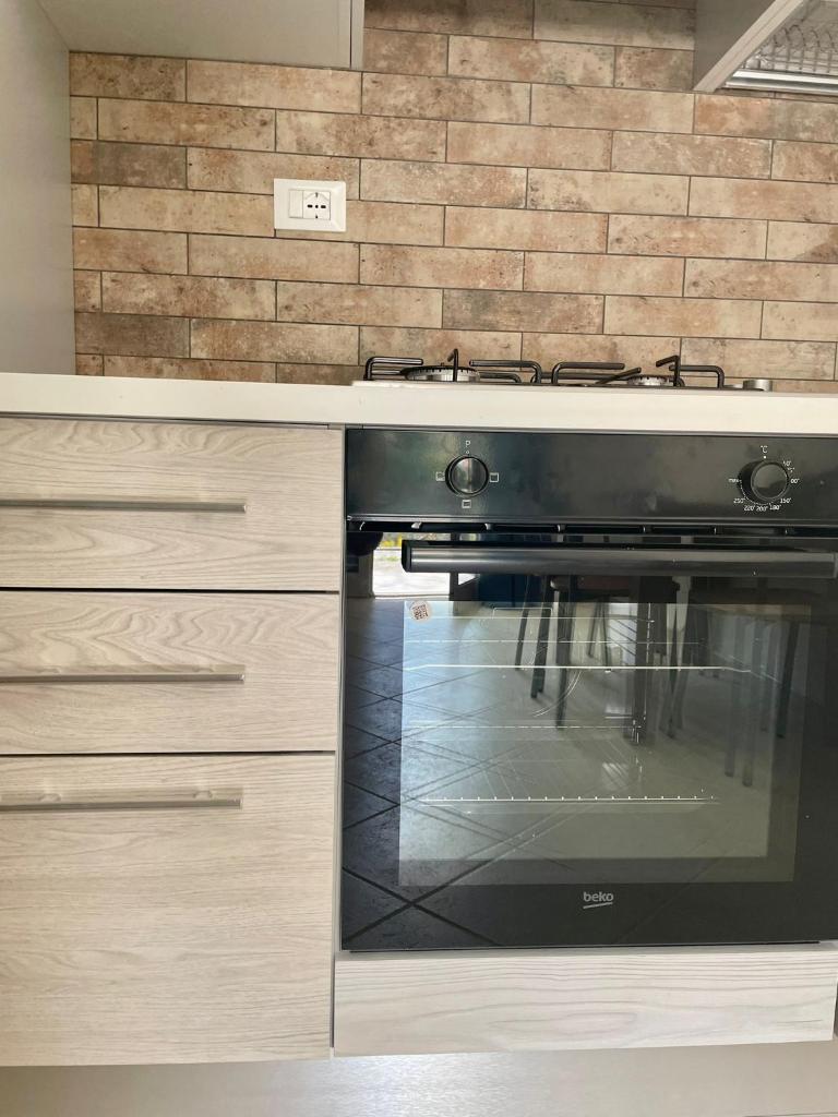 un four noir dans une cuisine avec des armoires en bois dans l'établissement ValGiuSi Resort, à Capo Vaticano