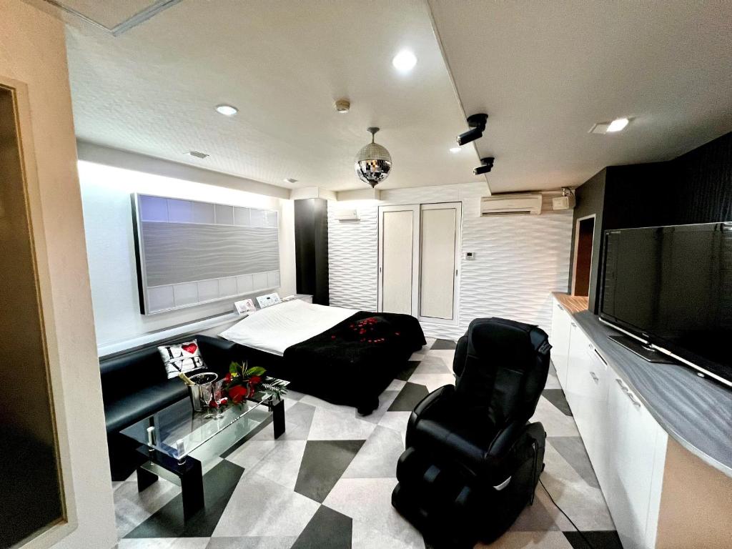 - un salon avec un lit, un canapé et une télévision dans l'établissement ホテル南の風風力3駒ヶ根店, à Komagane 10 autres photos