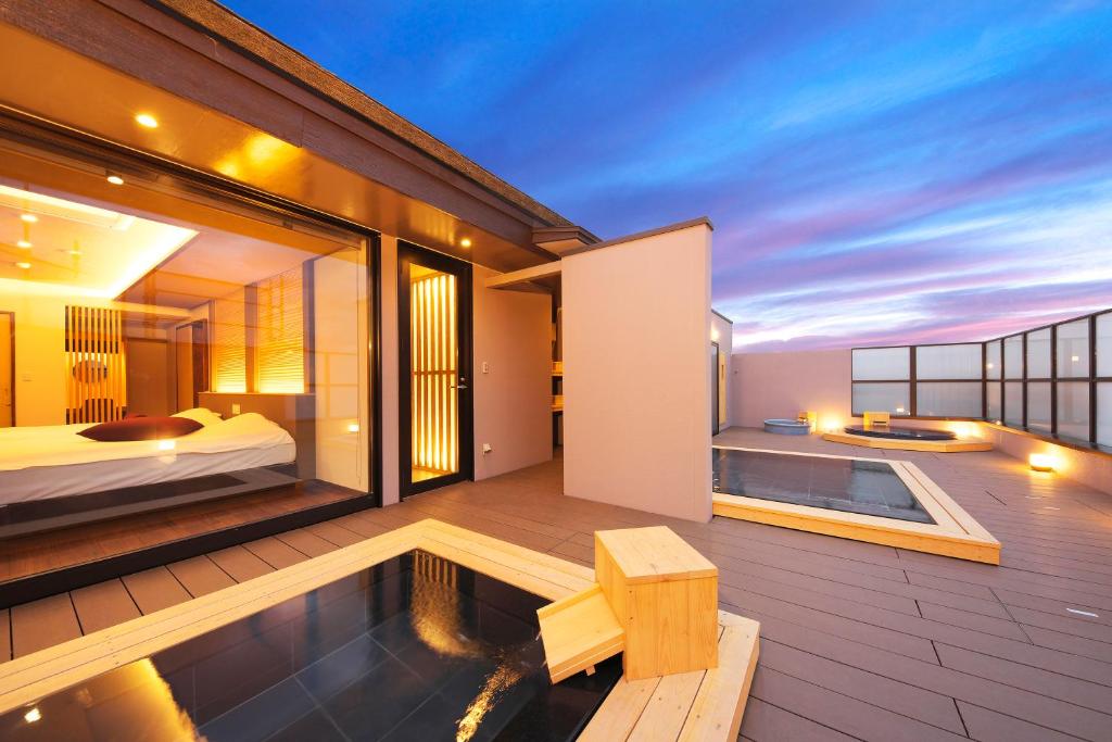 - un balcon d'une maison avec un lit et une piscine dans l'établissement Meitei no Yado Hotel Koshien, à Fuefuki