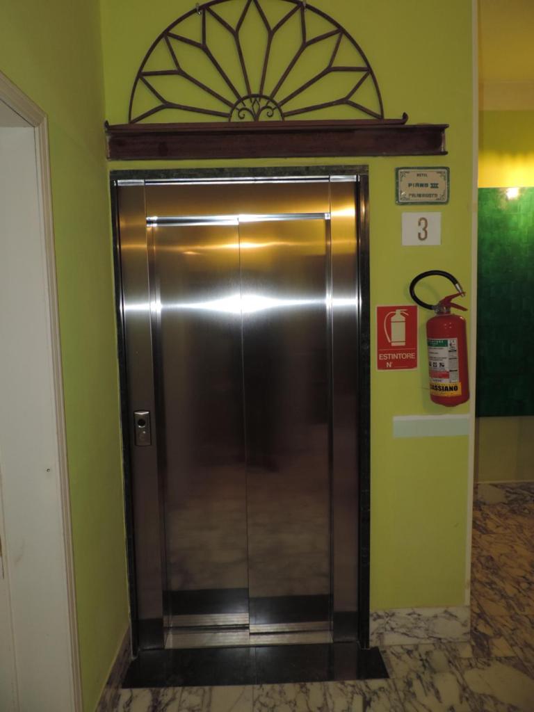 un ascenseur en acier inoxydable dans une chambre aux murs verts dans l'établissement Hotel Biagiotti, à Lido di Camaiore