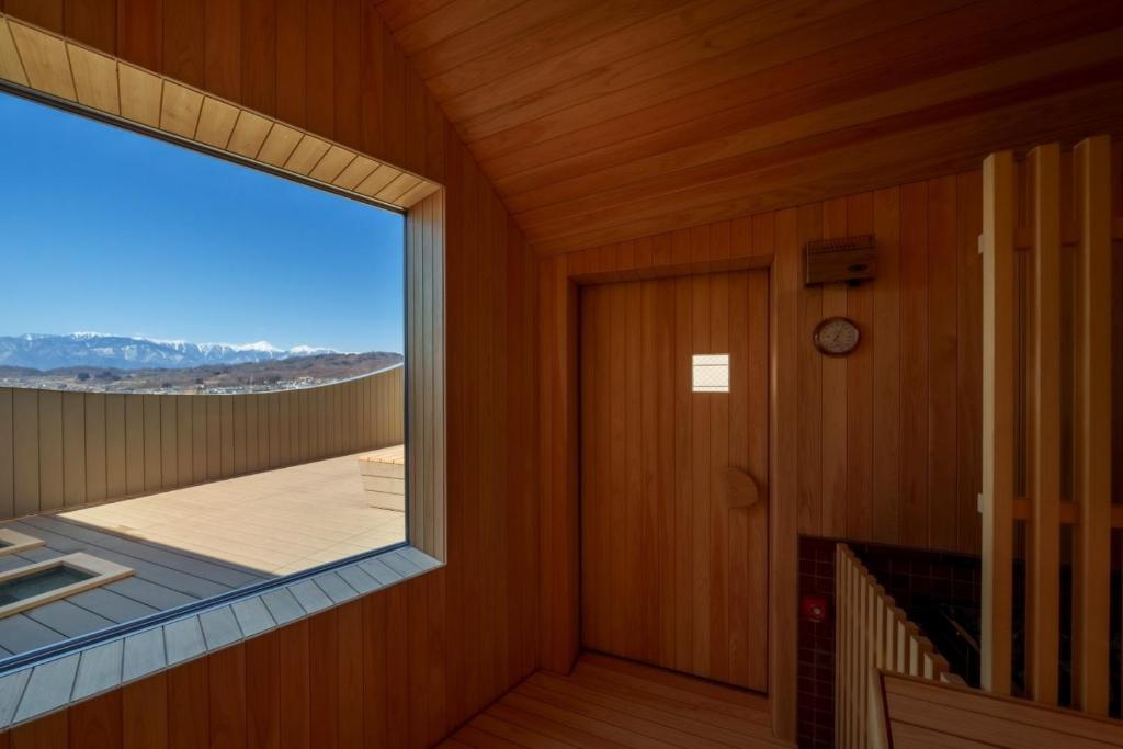 Cette chambre dispose d'une grande fenêtre et d'une porte. dans l'établissement onsen hotel OMOTO, à Matsumoto