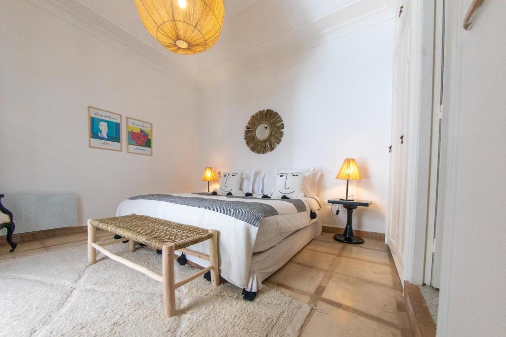 une chambre blanche avec un lit et une table dans l'établissement RIAD DAR C, à Marrakech