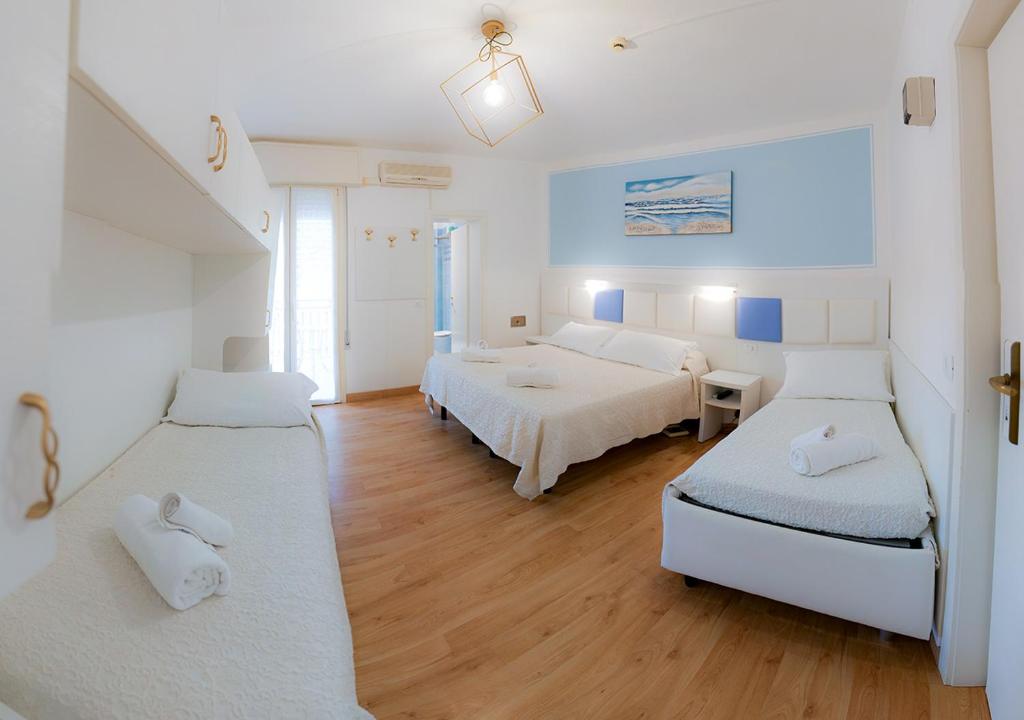 une grande chambre avec deux lits et une chambre avec dans l'établissement Hotel Gioiosa, à Cesenatico