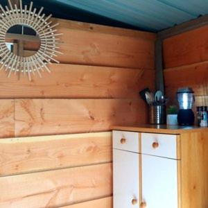 une pièce avec un mur en bois avec un miroir et une armoire dans l'établissement Le tipi à Marie, déconnectez- vous !!!, à Cambounès